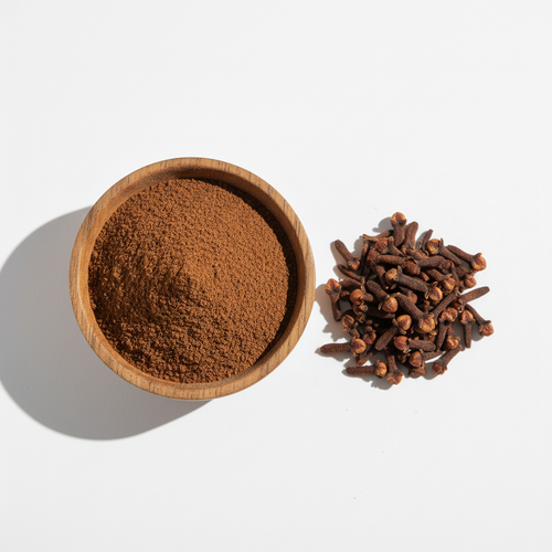 Cloves powder in a wooden bowl with whole cloves on white background