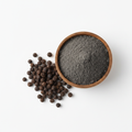 Black pepper powder in a wooden bowl with whole peppercorns on white background