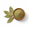 Bay leaves powder in a wooden bowl with dried bay leaves on white background