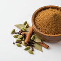 Garam masala powder in a wooden bowl with whole spices on white background