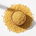 Whole fenugreek seeds in a wooden bowl on white background